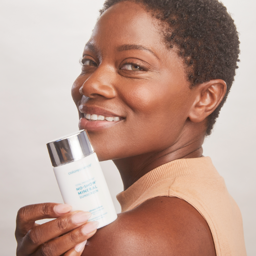 Model holding a bottle of sunscreen