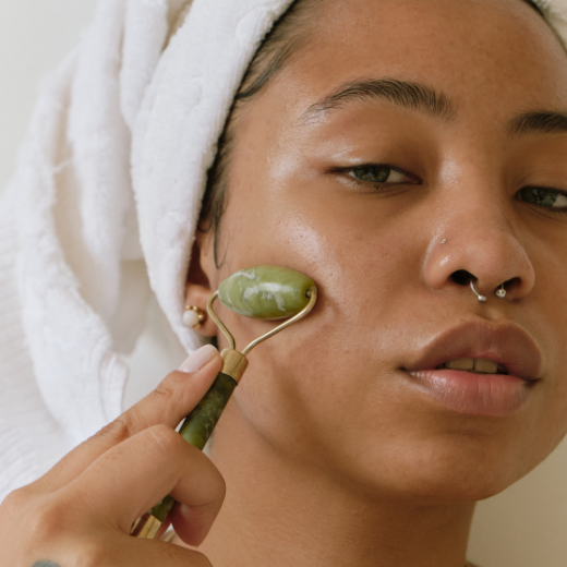 Woman using jade roller on face