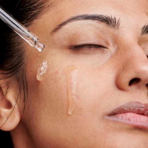 Woman applying serum to face
