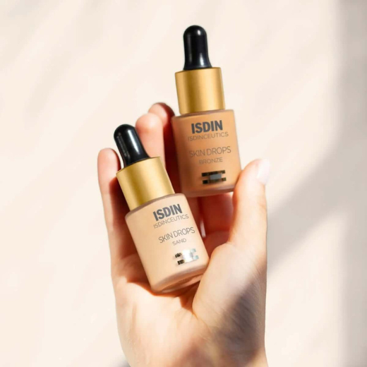 Bottles of ISDIN Skin Drops Make Up in sand and bronze