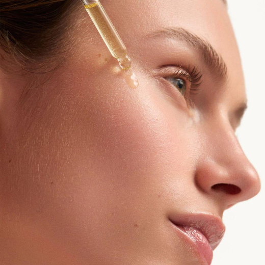 Woman Applying goop Beauty Skincare Serum To Cheek