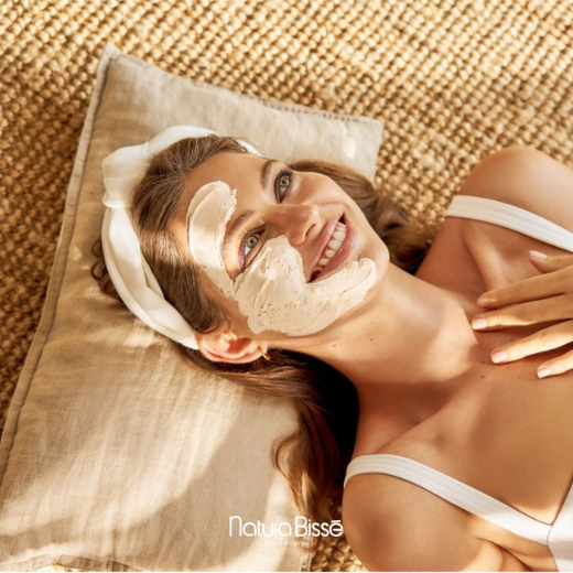 Woman with Natura Bisse Skincare products on