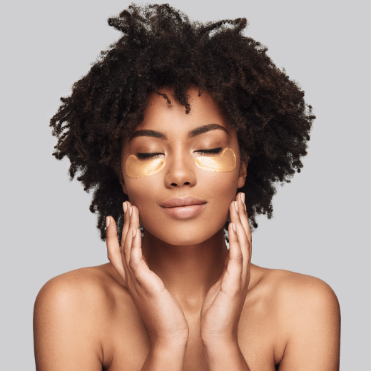 Woman with gold eye masks during a skin care routine