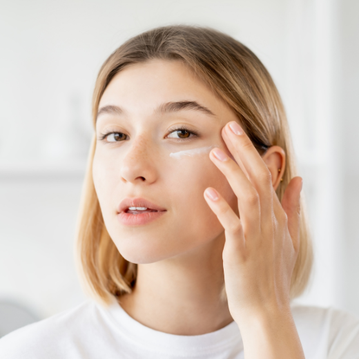 Woman applying moisturizer to face