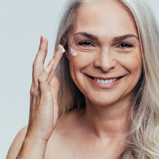 Woman applying moisturizer to dry skin