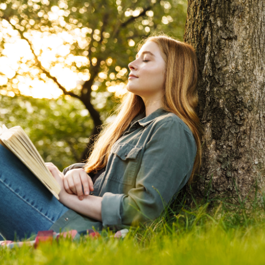 Image of a model outside relaxing by a tree