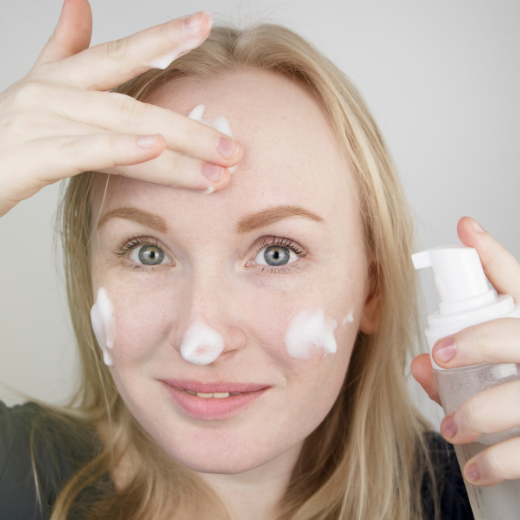Woman using a gentle foaming cleanser on skin prone to redness and rosacea