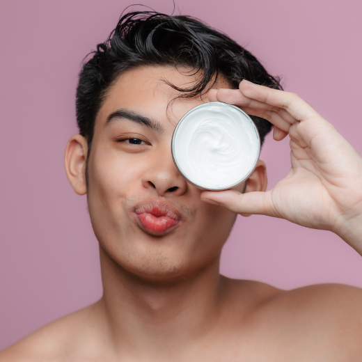 Man holding moisturizer over face and posing