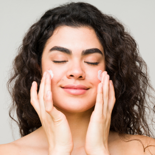 Woman applying sunscreen to face in the morning