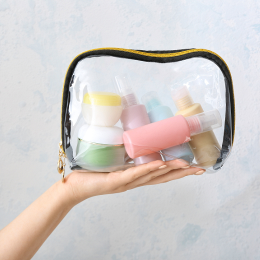 Image of hand model holding a bag of travel skin care products